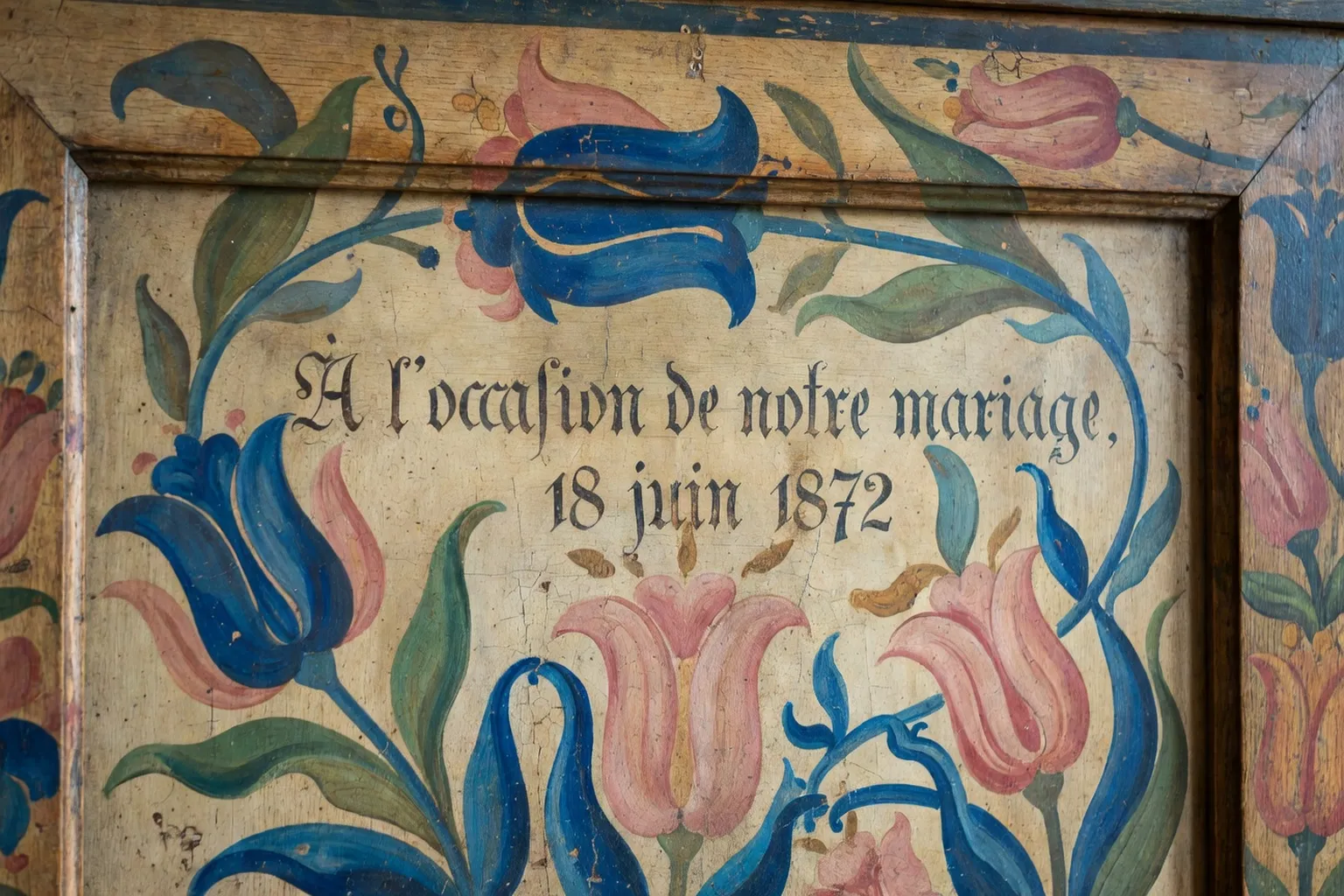 Détail d'une armoire alsacienne peinte avec motifs de tulipes et inscription de mariage